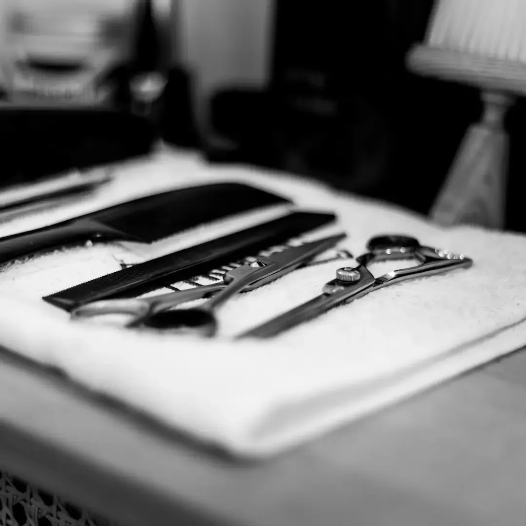 Rasoir, blaireau et ciseaux de barbier posés sur un plan de travail